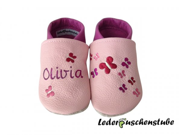 Lederpuschen in rosa-flieder; links 2 Schmetterlinge (dunkelrot-creme; orchidee.creme) Namen (flieder) und rechts Stickerei 9 Schmetterlinge (dunkelrot-rosa-orchidee-creme) 